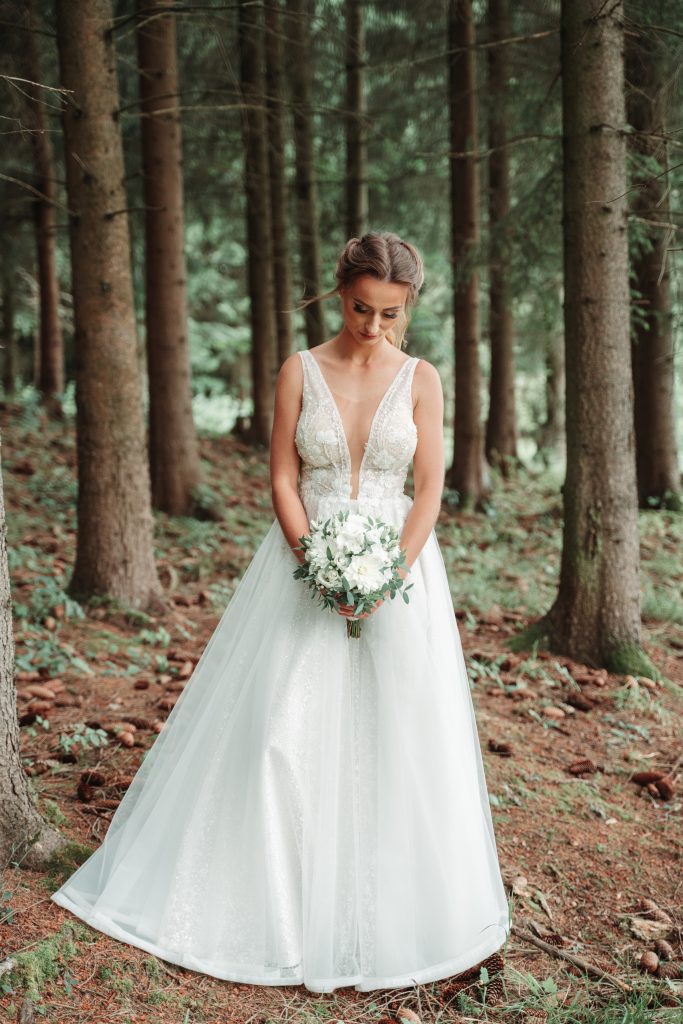 nevesta so svadobnou kyticou v lese